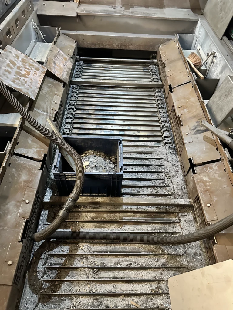 Reinigung einer Laserschneidanlage mit Industriesaugern zur Entfernung von Metallstaub und Schneidrückständen in einer Produktionshalle.